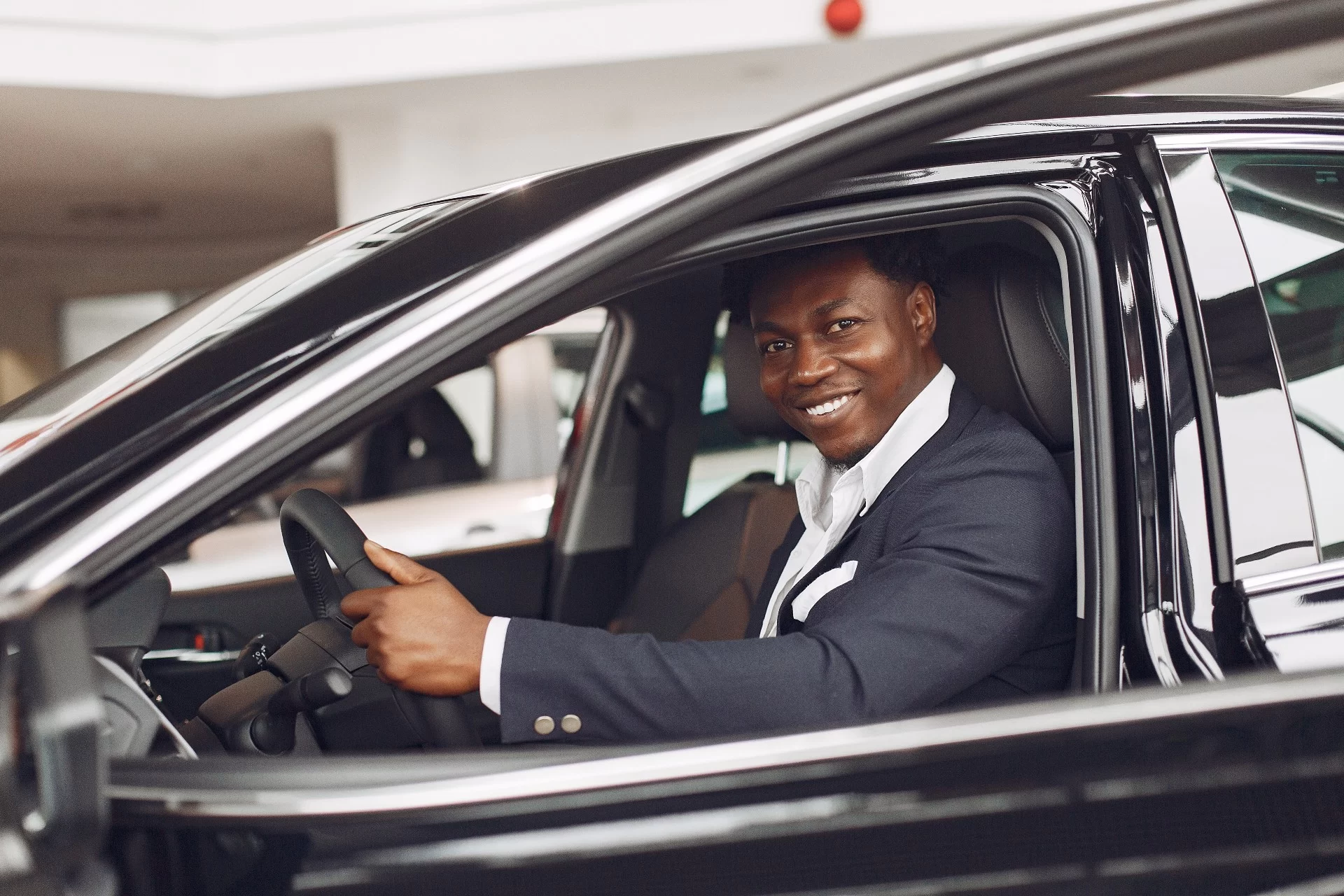 Elegant professional man on the steering wheel | car insurance in kenya