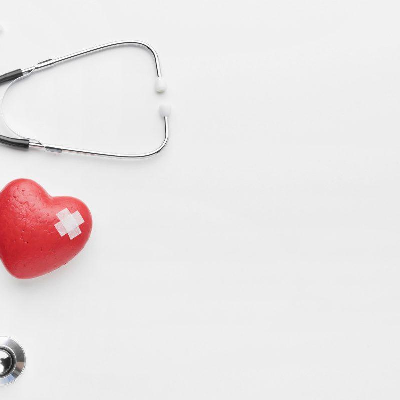 syringe, capsules and stethoscope with red stitched heart